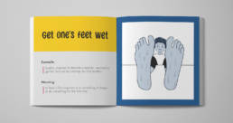 The image shows a mock-up of an opened picture book. An idiom 